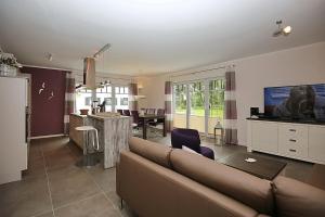 a large living room with a couch and a kitchen at Reethaus Am Mariannenweg 10b in Boltenhagen