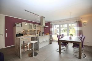 a kitchen with a table and a dining room at Reethaus Am Mariannenweg 10b in Boltenhagen