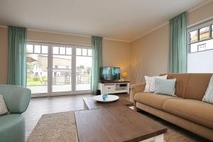 a living room with a couch and a tv at Reethaus Am Mariannenweg 08a in Boltenhagen