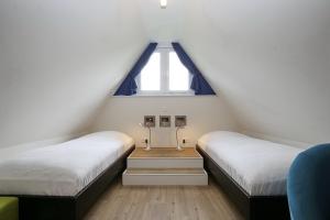 a attic bedroom with two beds and a window at Reethaus Am Mariannenweg 11b in Boltenhagen