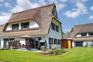 a house with a thatched roof and a yard at Reethaus Am Mariannenweg 11b in Boltenhagen