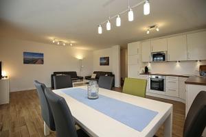 a kitchen and dining room with a table and chairs at Reethaus Am Mariannenweg 17a in Boltenhagen