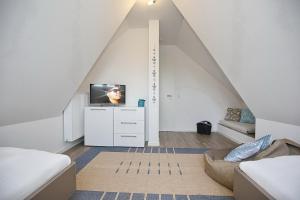 a attic room with a tv on a white dresser at Reethaus Am Mariannenweg 13a in Boltenhagen