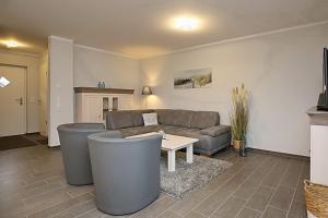 ein Wohnzimmer mit einem Sofa und einem Tisch in der Unterkunft Reethaus Am Mariannenweg 01a - Sylt in Boltenhagen