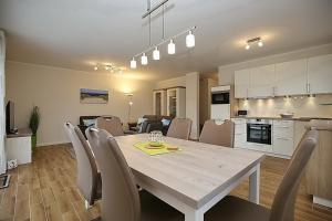 a kitchen and dining room with a table and chairs at Reethaus Am Mariannenweg 01b - BaTa in Boltenhagen