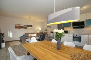 een keuken en een woonkamer met een tafel en een bank bij Reethaus Am Mariannenweg 13b in Boltenhagen