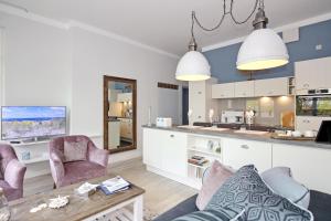 奥斯赛拜-屈隆斯博恩La Mer Wohnung 07的一间厨房和一间带两把椅子和一张桌子的客厅