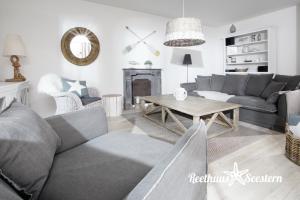 ein Wohnzimmer mit einem Sofa und einem Tisch in der Unterkunft Reethaus Am Mariannenweg 05a - Reethuus Seestern in Boltenhagen