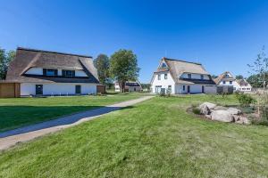 una casa con un patio de hierba al lado de una casa en Reethaus Am Mariannenweg 05a - Reethuus Seestern en Boltenhagen