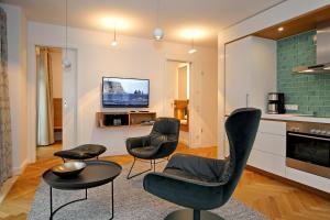 ハイリゲンダムにあるLinden-Palais Wohnung 28のリビングルーム(椅子、テーブル、テレビ付)