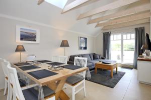 a dining room and living room with a table and chairs at Haus am Wald Wohnung Strand in Wittenbeck