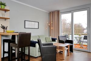 uma sala de estar com um sofá e uma mesa em Villa Patricia Wohnung 11 em Kühlungsborn