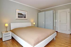 キュールングスボルンにあるVilla Patricia Wohnung 11のベッドルーム1室(大型ベッド1台、白いキャビネット付)