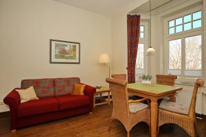 uma sala de estar com um sofá vermelho e uma mesa em La Mer Wohnung 08 em Kühlungsborn