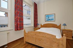 奥斯赛拜-屈隆斯博恩La Mer Wohnung 08的带一张木床和两扇窗户的卧室