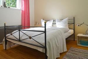 1 dormitorio con cama negra y almohadas blancas en Auf den Höfen Wohnung 02, en Kühlungsborn