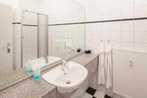 uma casa de banho branca com um lavatório e um espelho em Meeresblick Wohnung 023 em Kühlungsborn