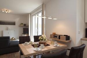 ein Esszimmer und ein Wohnzimmer mit einem Tisch und Stühlen in der Unterkunft Residenz von Flotow Wohnung 09 in Heiligendamm