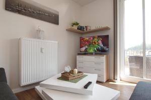 ein Wohnzimmer mit einem TV und einem weißen Couchtisch in der Unterkunft Residenz von Flotow Wohnung 09 in Heiligendamm