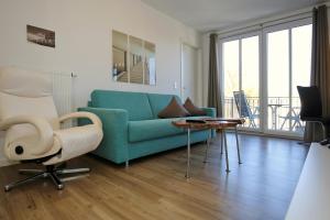 salon z niebieską kanapą i stołem w obiekcie Residenz von Flotow Wohnung 10 w mieście Heiligendamm