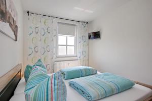 ein Bett mit zwei Kissen und ein Fenster in einem Zimmer in der Unterkunft Residenz von Flotow Wohnung 12 in Heiligendamm
