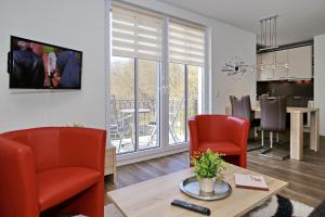 een woonkamer met stoelen en een tafel en een eetkamer bij Residenz von Flotow Wohnung 12 in Heiligendamm