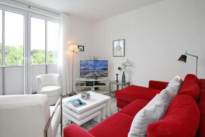 ハイリゲンダムにあるResidenz von Flotow Wohnung 14のリビングルーム(赤いソファ、テレビ付)