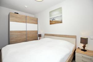 ハイリゲンダムにあるResidenz von Flotow Wohnung 15のベッドルーム(白いベッド1台、木製ヘッドボード付)