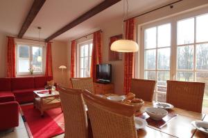 a living room with a table and a red couch at Ferienhaus Nanni in Wittenbeck