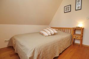 a bedroom with a bed and a night stand with a lamp at Ferienhaus Nanni in Wittenbeck