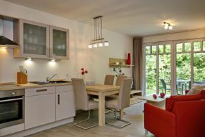 eine Küche und ein Esszimmer mit einem Tisch und Stühlen in der Unterkunft Linden-Palais Wohnung 06 in Heiligendamm