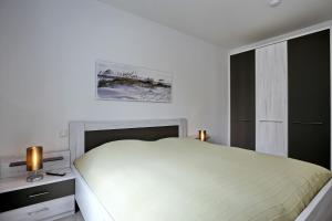 ハイリゲンダムにあるLinden-Palais Wohnung 20の白いベッドルーム(ベッド1台、窓付)