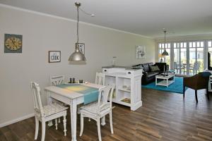 eine Küche und ein Wohnzimmer mit einem Tisch und Stühlen in der Unterkunft Linden-Palais Wohnung 03 in Heiligendamm