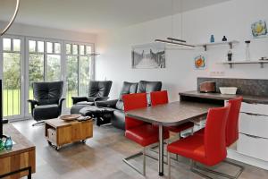 sala de estar con mesa y sillas rojas en Linden-Palais Wohnung 18, en Heiligendamm