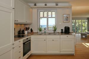 eine Küche mit weißen Schränken und einem großen Fenster in der Unterkunft Linden-Palais Wohnung 38 in Heiligendamm
