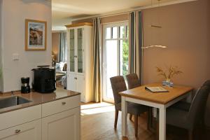 eine Küche und ein Esszimmer mit einem Tisch und einem Fenster in der Unterkunft Linden-Palais Wohnung 38 in Heiligendamm