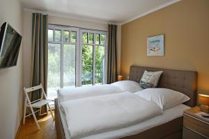 ハイリゲンダムにあるLinden-Palais Wohnung 38のベッドルーム1室(白いベッド2台、窓付)