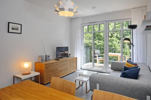 uma sala de estar com um sofá, uma televisão e uma mesa em Linden-Palais Wohnung 21 em Heiligendamm
