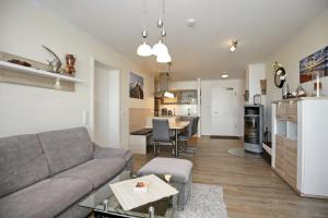 a living room and kitchen with a couch and a table at Villa Strandvogt Wohnung 11 in Börgerende-Rethwisch