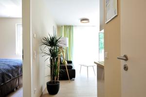 ハイリゲンダムにあるLinden-Palais Wohnung 11のベッド1台と鉢植えの植物2本が備わる部屋