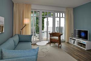 ハイリゲンダムにあるLinden-Palais Wohnung 26のリビングルーム(青いソファ、テレビ付)