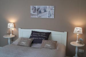 a bed with two pillows on it with two tables at Linden-Palais Wohnung 12 in Heiligendamm