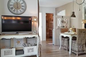 a living room with a flat screen tv on a tv stand at Linden-Palais Wohnung 12 in Heiligendamm