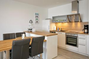 uma cozinha com uma mesa de madeira e uma bancada em Linden-Palais Wohnung 16 em Heiligendamm