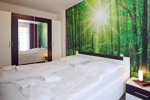 ハイリゲンダムにあるLinden-Palais Wohnung 02の緑の森の壁画が施されたベッドルーム1室(白いベッド1台付)
