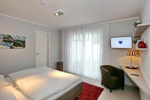 Schlafzimmer mit einem Bett, einem Schreibtisch und einem Stuhl in der Unterkunft Linden-Palais Wohnung 37 in Heiligendamm