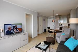 een woonkamer met een flatscreen-tv op een witte kast bij Linden-Palais Wohnung 15 in Heiligendamm