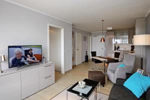 a living room with a flat screen tv on a white cabinet at Linden-Palais Wohnung 15 in Heiligendamm