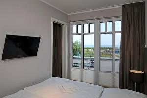 ハイリゲンダムにあるLinden-Palais Wohnung 15のベッドと大きな窓が備わるホテルルームです。