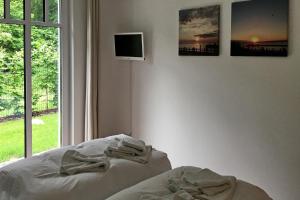 een slaapkamer met een bed en een tv aan de muur bij Linden-Palais Wohnung 07 in Heiligendamm